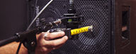LEWITT microphone is getting positioned in front of bass amp